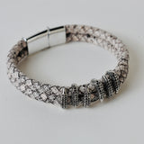 Black leather braided strap with silver and gold color embellishment