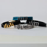 Black leather braided strap with silver and gold color embellishment